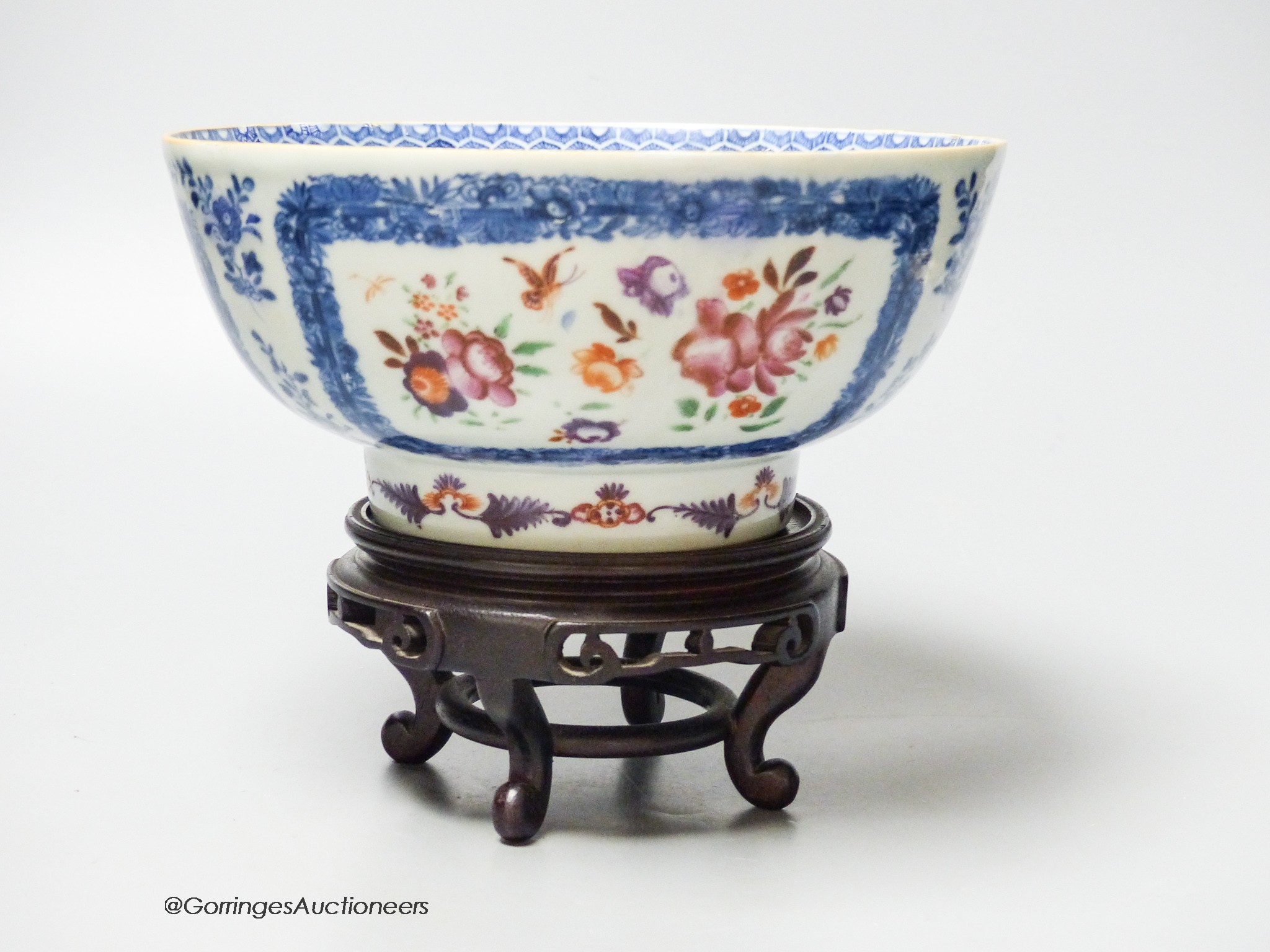 A 18th century Chinese export porcelain footed punch bowl on hardwood stand, diameter 20cm, restored